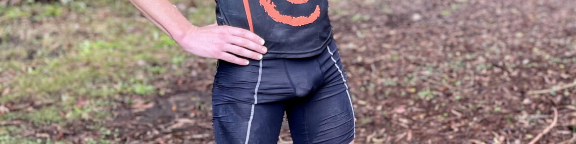 Coach Trent Renshaw in running tights pointing the way during a forest-to-lake run from Blackbutt to Balarang.
