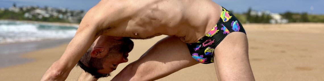 Coach Trent Renshaw performing a modified Cossack squat stretch after a soft sand run on Bombo Beach.
