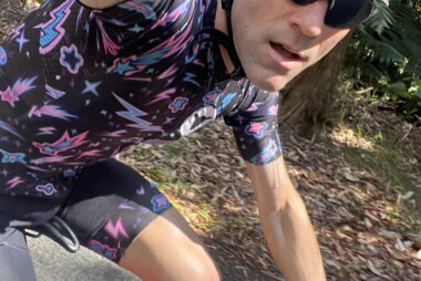 Coach Trent Renshaw cycling uphill on a road bike towards Bruxner Gap.