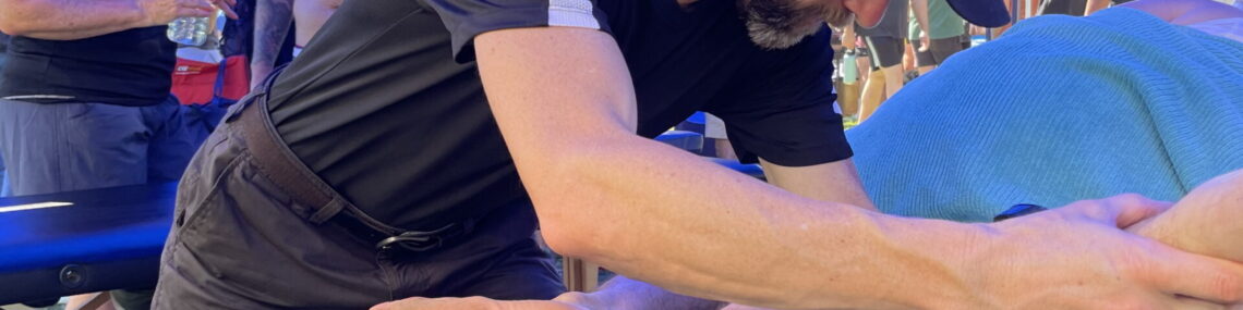 Massage therapist Trent Renshaw treating a runner’s adductors with a passive soft tissue release technique in a side-lying position at the Coffs Run Festival 2024.