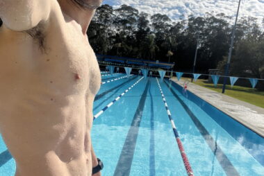 Coach Trent Renshaw standing in swim briefs at the shallow end of the Coffs Harbour Olympic Pool after completing a swim training session.