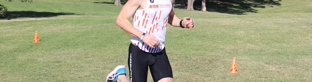 Coach Trent Renshaw wearing Coffs Tri Club singlet and black tights at Shellharbour Parkrun.