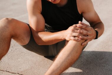 Sportsman holding his knee in discomfort after exercise, symbolising joint pain and the impact of arthritis on athletes.