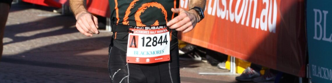 Trent Renshaw with a beard crossing the finish line at the Blackmore’s Running Festival.